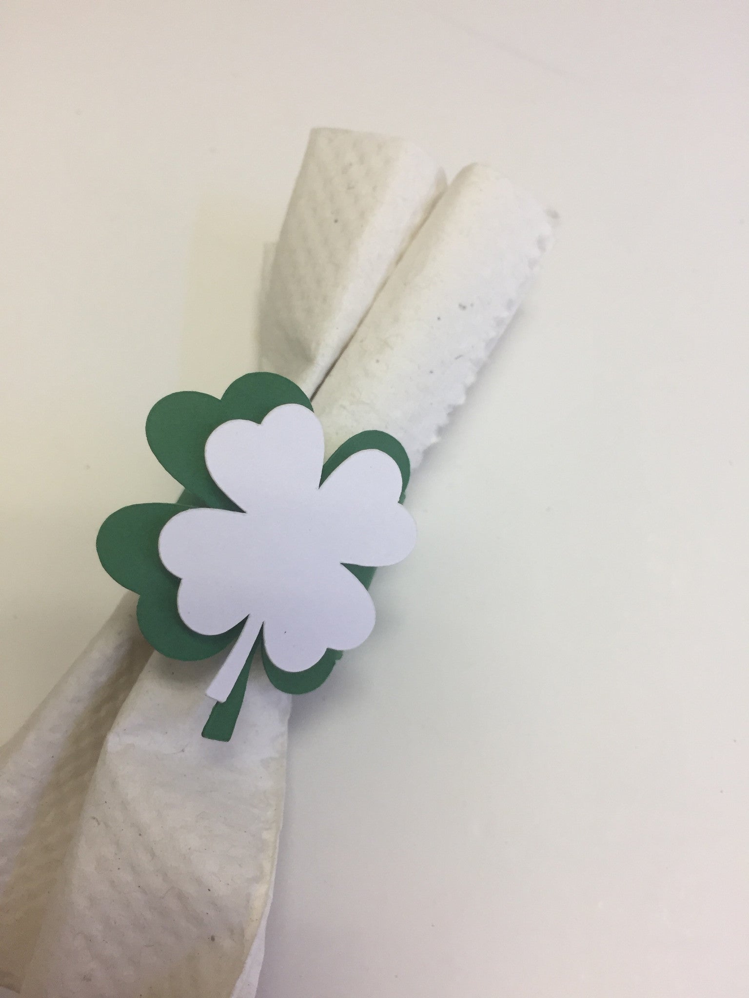 Green Clover with a white clover on top of a wrap around napkin ring.